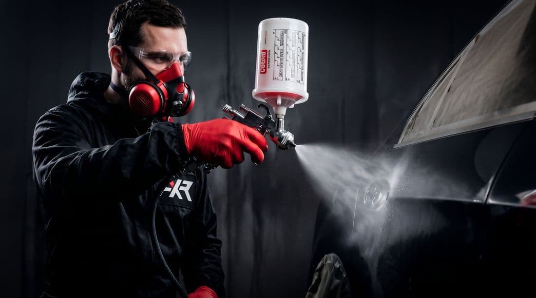 Pistolet de peinture AXR en action sur un capot